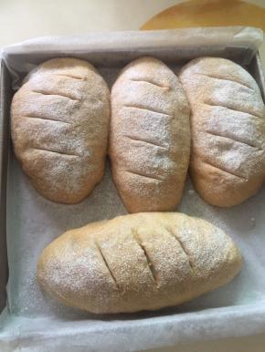 二发时间到后取出面团和水，预热烤箱190度，面团撒上干粉割口