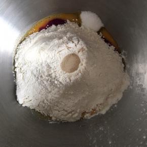 再倒入面粉，面粉中间挖一个小坑，倒入干酵母粉，启动低档进行和面