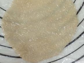 将剂子上面放上保鲜膜，用擀面杖擀成圆片