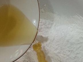 将糯米粉和玉米淀粉加入碗中，在把油倒入