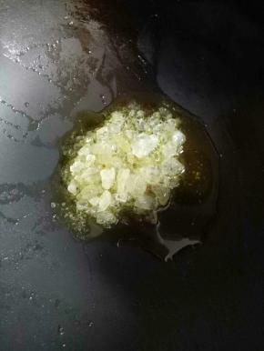 锅里流底油，加入冰糖翻炒几下