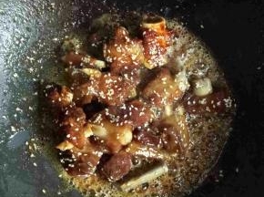 等汤汁只剩下一小半的时候，加入白芝麻翻炒，再加入盐，鸡精1小勺，大火收汁，让汤汁全部裹在排骨上即可
