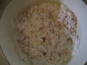 用筷子把胡萝卜泥与面粉搅拌，直至面粉呈雪花状；