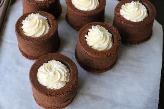 将淡奶油挤入巧克力蛋糕杯中