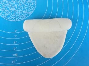 擀成长条状，自上而下卷起。