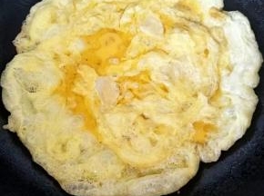 沿着锅一圈倒入鸡蛋液，形成饼状。