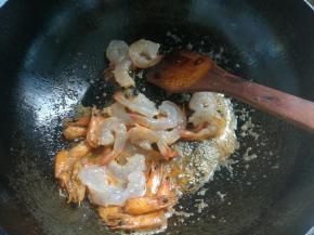 锅内放油，油热下入葱蒜煸炒出香味，放入虾头。