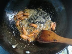 用铲刀把虾头挤压出红油。