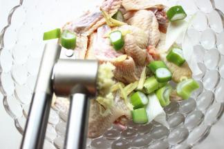 处理好的鸡翅，加入葱姜末和盐，蒜用压蒜器压成蒜蓉。