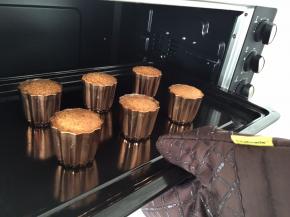 当烤至30分钟后，面糊高于模具时，将可露丽拿出来，逐个轻敲模具，让面糊重新回到模具内，全部过程最少敲3一5次