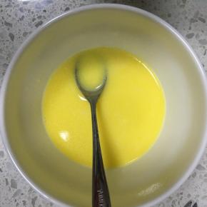 黄油加牛奶加热融化，滴入香草精，混合均匀，再加入一勺翻拌好的面糊，搅拌均匀