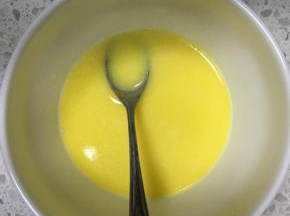 黄油加牛奶加热融化，滴入香草精，混合均匀，再加入一勺翻拌好的面糊，搅拌均匀
