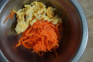 将炒好的鸡蛋+挤干水分的胡萝卜丝+一点点盐+麻油拌匀备用