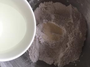 粉类混合均匀后，挖一个小孔倒入酵母，然后慢慢倒入水
