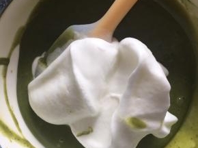 取1/3的蛋白霜到抹茶蛋黄糊中，上下翻拌均匀