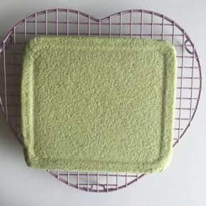 取出蛋糕在网架上，趁热撕去油纸，再盖上油纸，以免蛋糕干裂