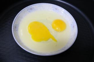 盘子内打入两个鸡蛋，搅打均匀