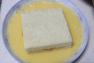 将摆好的西多士两面及四周均匀的粘上鸡蛋牛奶液