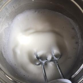 打发至泡沫细腻时，再加入1/3的细砂糖继续打发，接着打发到有纹路时倒入剩下的细砂糖继续打发