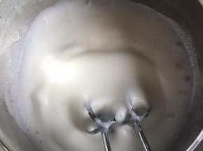 打发至泡沫细腻时，再加入1/3的细砂糖继续打发，接着打发到有纹路时倒入剩下的细砂糖继续打发