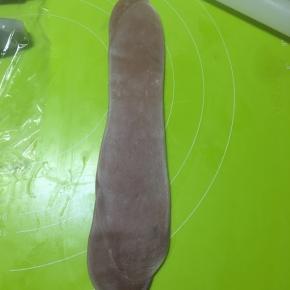 松弛好以后的面卷再一次擀成牛舌状
