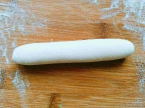 拿出面团，用力揉，直到揉到表面光滑，看起来有透亮的感觉，切开断层没有气泡，说明面团已经揉好，然后搓成长条