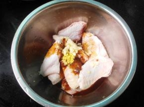 将调味汁倒入鸡翅中，加入切末的蒜末姜末