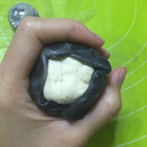 取切开的面卷压扁擀成饺子皮状，包住乳酪蛋黄馅，收口