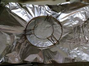 把锡纸放在烤架下来，沿着烤架边缘向圈一个圆柱形，方便在砂锅里成形。