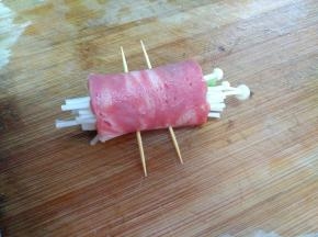 把所有材料慢慢卷起来，用两颗牙签把培根卷固定。