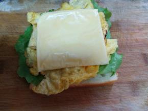 把鸡蛋饼和芝士片放在生菜上。