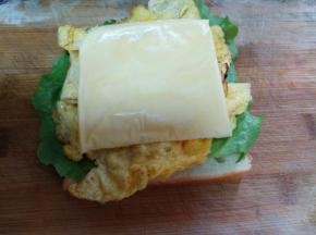 把鸡蛋饼和芝士片放在生菜上。