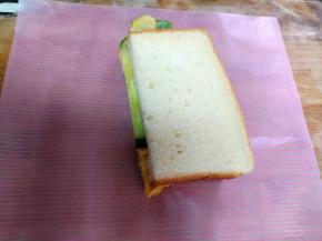 把三明治一分为二，用油纸包起来，就可以食用了。