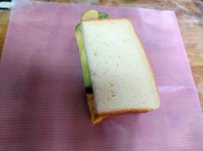 把三明治一分为二，用油纸包起来，就可以食用了。