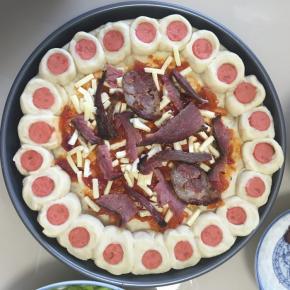 披萨上先刷一层自制披萨酱，然后铺一层马苏里拉芝士碎，放上撕小的腊肉和香肠，再撒上一层马苏里拉芝士碎