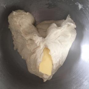 接着一直不停揉，揉成团后加入软化的黄油，继续揉搓