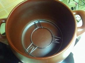把烤架放在砂锅里面（烤架如果高了，可以把烤架脚折弯）。