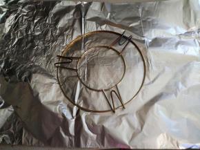 把锡纸放在烤架下面，沿着烤架边缘向圈一个圆柱形，方便在砂锅里成形。（新砂锅不要洗，用拧干的湿毛巾擦干净，直接用于烧烤。）