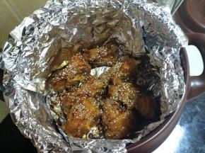 把排骨翻身后，刷上烧烤酱和撒上白芝麻。然后盖上盖子继续烤。