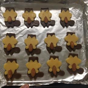 把咖啡色身体用脸部模具按压取出，把原色脸部安上，再安上小手，用杏仁沾一点蛋液粘在小松鼠双手之间，烤箱预热180度，上下火，烤15分钟