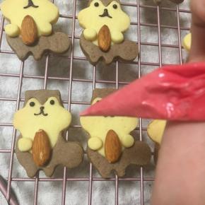 白色巧克力放入裱花袋，隔水融化，加入一滴红色色素，揉搓均匀颜色，裱出小松鼠的腮红和尾巴