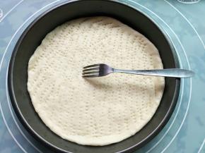 把面片放入披萨盘子里，用手在中心点往四周挤，使中间薄，边缘稍厚；用叉子戳洞，以免烤制中拱起