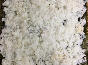将稍微有温度的米饭均匀的铺在紫菜上面