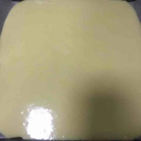 烤盘内铺一张烘焙油纸，倒入蛋糕糊，轻轻震几下除去大气泡。