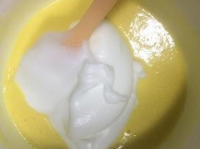 取1/3的蛋白霜到蛋黄糊中，刮刀翻拌均匀