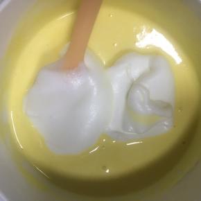 继续加入1/3的蛋白霜到翻拌均匀的蛋糕糊中，继续翻拌均匀