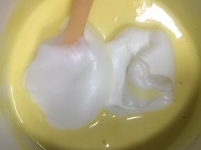 继续加入1/3的蛋白霜到翻拌均匀的蛋糕糊中，继续翻拌均匀