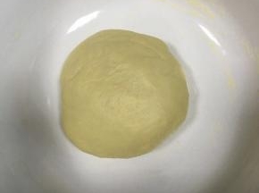 面团再揉圆放在碗中，盖上湿毛巾，放入烤箱发酵，烤箱下层烤盘内倒入温水，中层放上网架，碗放在网架上进行发酵，40分钟