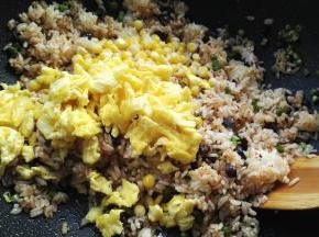 用木铲翻拌均匀，倒入玉米粒、炒好的鸭蛋。