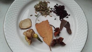 准备好的调料装料盒中（姜、香叶、八角、白芷、桂皮、小茴香、红曲米等）。